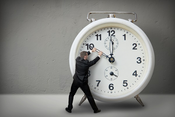 Businessman pulling a clock hand backwards